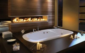 Beautiful modern fireplace lights up this bath area