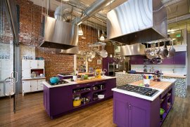 Industrial style kitchen with bold purple cabinets