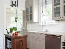 Transitional kitchen with a tiny island and beautiful lighting [Design: TerraCotta Studio]